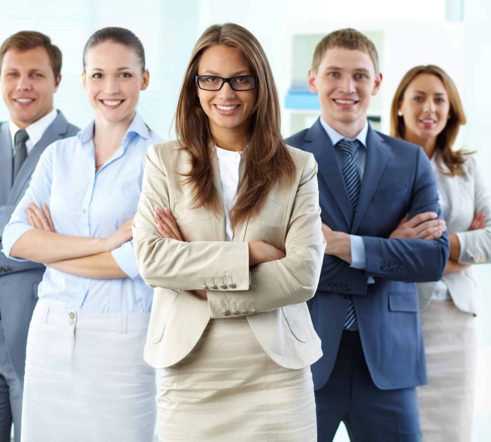 Confident business team with a female leader looking at camera and smiling